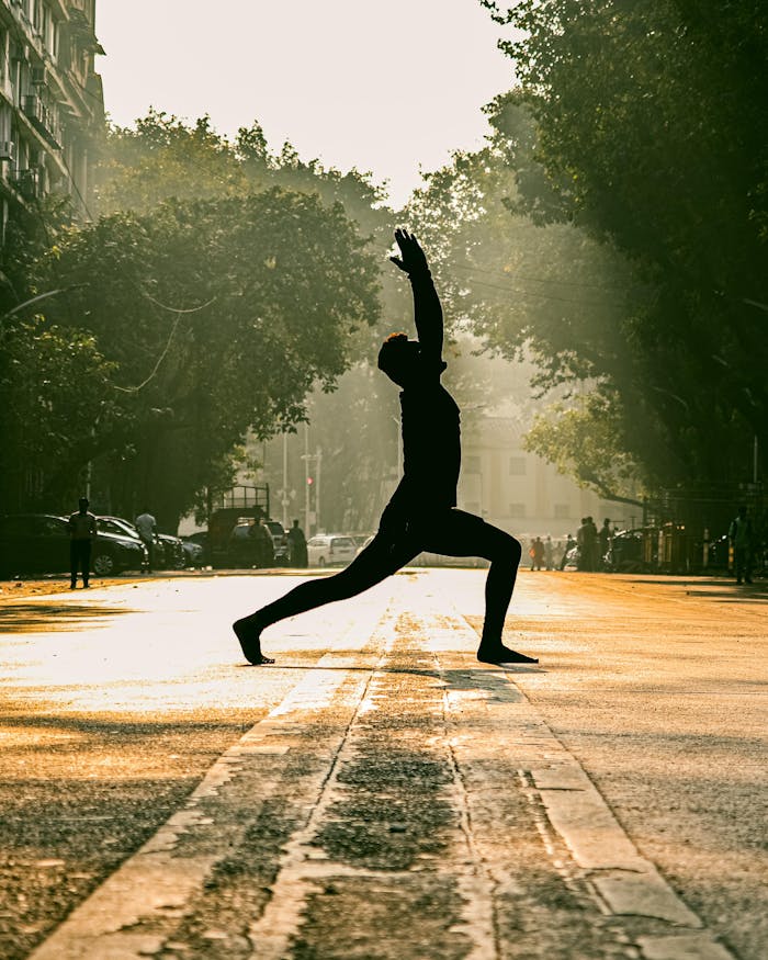 Silhouette of a person practicing yoga on a street in Mumbai at sunrise, creating a serene and vibrant scene.
